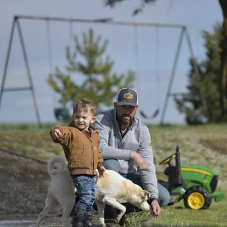A farmer and his son on the field